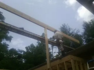 Carpenter setting a ridge beam over a new addition frame — Ice Dam Removal by Roofing Brothers in Dousman