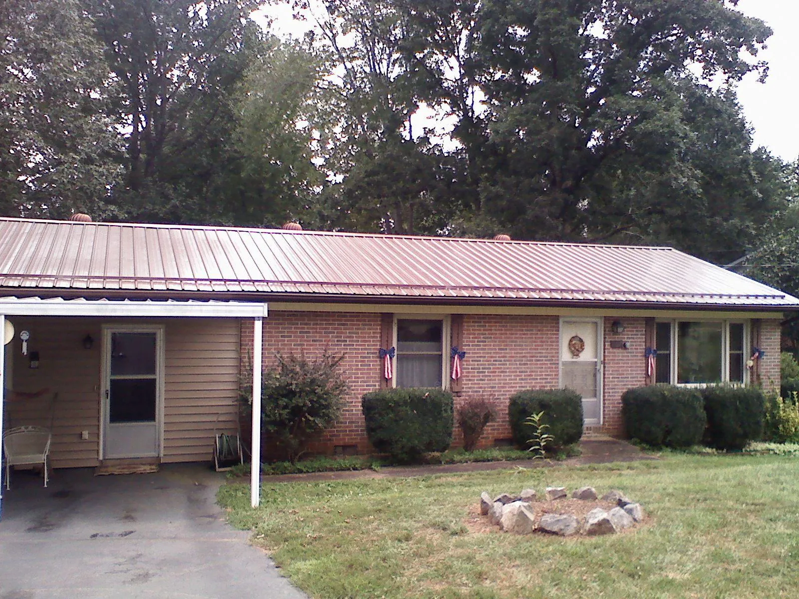 Bronze metal roof and carport on a brick ranch home — Roof Repair work by our crew in Dousman