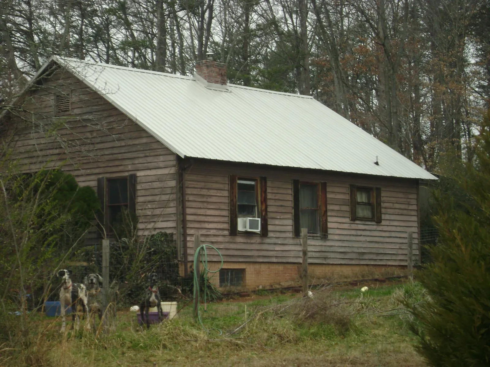 White metal roof on an old wood sided farmhouse, from a Metal Roof Installation job in Dousman